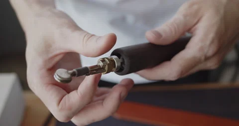Installing electric grooving iron into the handle for leather work close-up Stock Footage 144890918