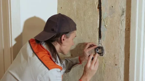 Installing an electrical outlet. 2 Shots. Stockbeeldmateriaal 219950213