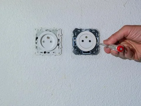 Installing electrical wall socket during home renovation Stock Photos