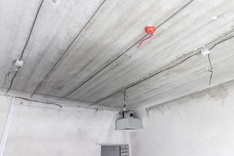 Installing electrical wiring for lamps through a precast concrete ceiling Stock Photos