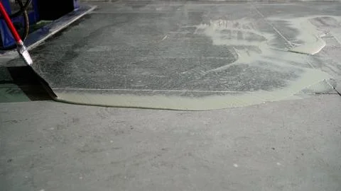 Installing an epoxy floor over existing concrete. Smoothing the primer over.. Stock Photos