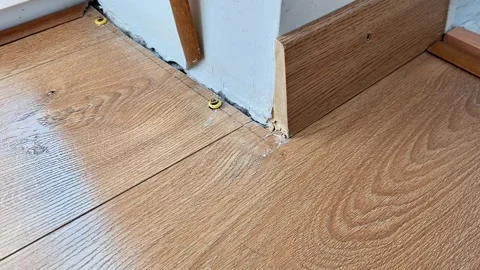 Installing Expansion Spacers Along Laminate Flooring Near Baseboard Stock Footage 340948294