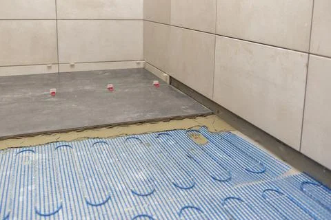 Installing a floor heating system under ceramic tiles in bathroom Stock Photos