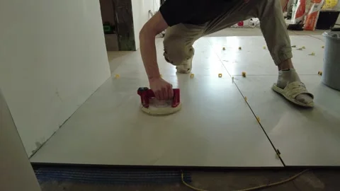 Installing floor tiles in a residential building during the day with tools for p Stock Footage 332455404