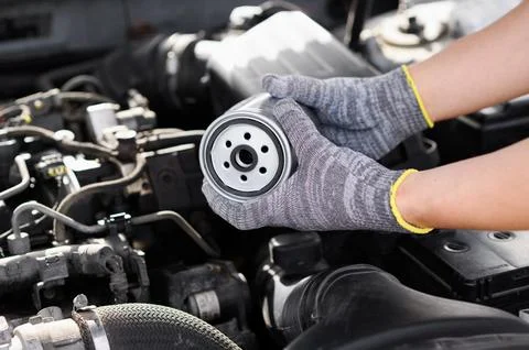 Installing fuel filter under hood of car. Man performs maintenance on diesel car Stock Photos