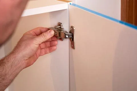 Installing a furniture hinge on the door. Assembling furniture and fixing f.. Stock Photos