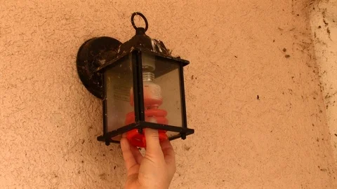 Installing Halloween Orange Light Bulb into Light Fixture Video stock 91578401