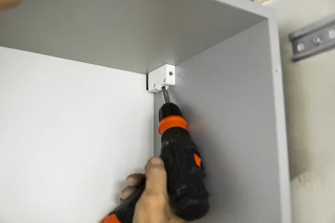 Installing a hardware kitchen cabinet suspension brackets on a custom kitchen Stock Photos