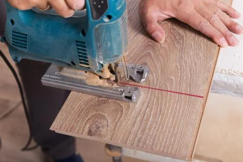 Installing laminate flooring. Carpenter cut parquet floor board Foto stock