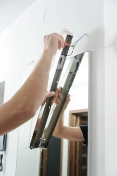Installing the lamp above the mirror. Stock Photos
