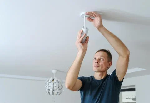 Installing a lamp at home. Stock Photos