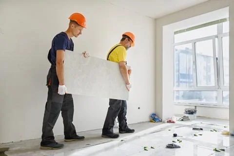Installing a large ceramic tile. Stock Photos