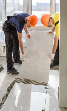 Installing a large ceramic tile. Stock Photos