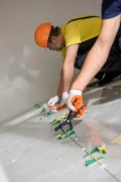 Installing a large ceramic tile. Stock Photos