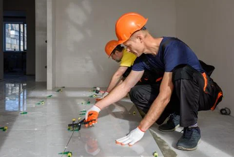 Installing a large ceramic tile. Stock Photos