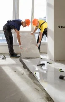 Installing a large ceramic tile. Stock Photos