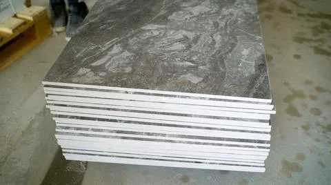 Installing a large ceramic tile. Workers are laying large tiles over a large 스톡 사진