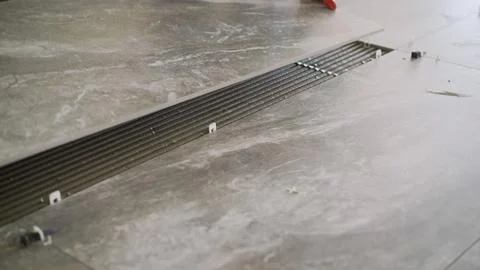 Installing large format gray porcelain tiles on floor with fresh combed adh.. Stock Photos