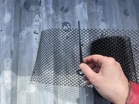 Installing leaf guard mesh in gutter Stock Photos