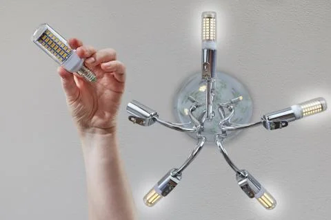 Installing LED lamp corn on the ceiling fixture. Stock Photos