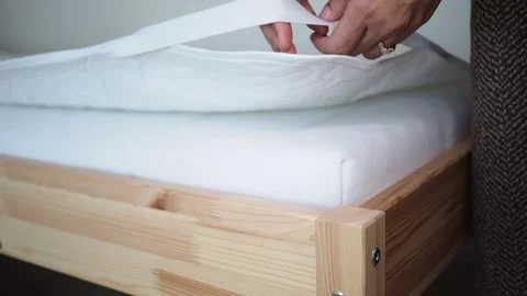Installing a mattress on a wooden bed frame Stock Footage 335855951