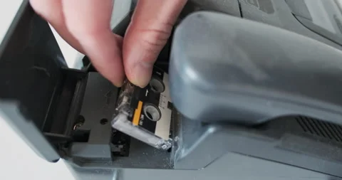 Installing a micro cassette into an old telephone answering machine, analog 動画素材 289305170
