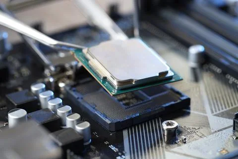 Installing modern computer chip onto motherboard, closeup Stock-Fotos