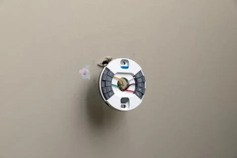 Installing mounting plate for modern round thermostat for air conditioning un Stock Photos
