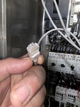 Installing a Network in a Tech Space With an Ethernet Connector in Hand Stock Photos