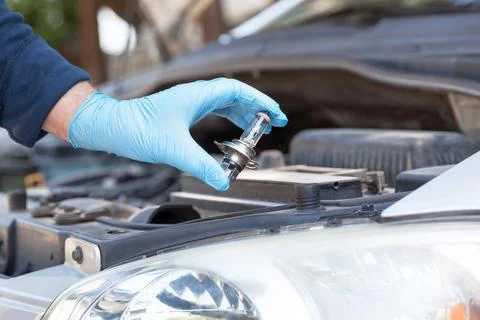 Installing new car headlight bulb Stock Photos