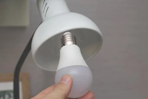 Installing new led lamp in table reading light Stock Photos