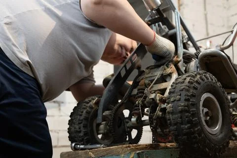 Installing a new part on an ATV to replace a broken old one. Do-it-yourself Stock Photos