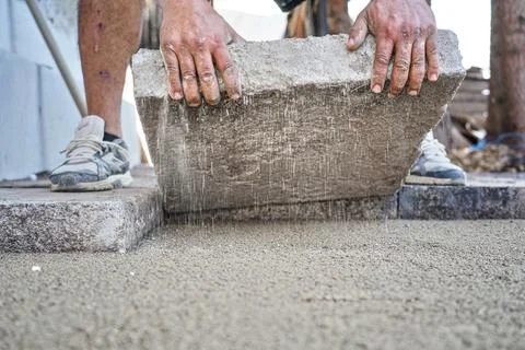 Installing new pavement or floor outside from large concrete tiles, closeup.. Stock Photos