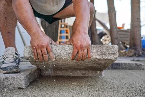 Installing new pavement or floor outside from large concrete tiles, closeup.. Stock Photos