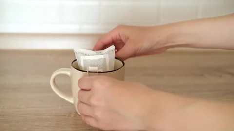 Installing a paper coffee drip bag on the ceramic beige mug. Making freshly Video stock 307275050