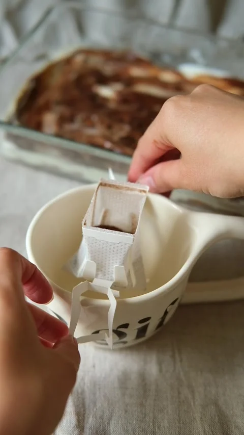 Installing a paper coffee drip bag on the ceramic beige mug. Making freshly Stock Footage 308661154