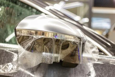 Installing PPF on the mirror of the car. Stock Photos