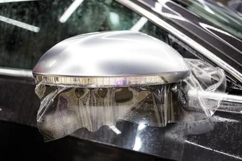 Installing PPF on the mirror of the car. Stock Photos
