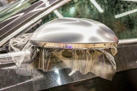 Installing PPF on the mirror of the car. Stock Photos