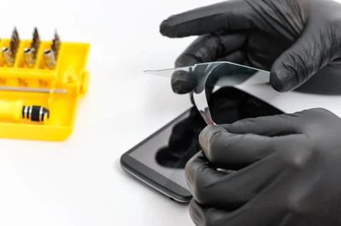 Installing a protective glass on the screen of a smartphon Stock Photos