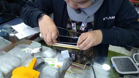  installing a protective glass on the screen of a smartphone.  Stock Footage 105999801