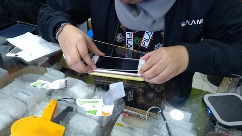  installing a protective glass on the screen of a smartphone.  Stock Footage 105999954