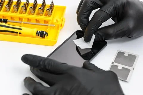 Installing a protective glass on the screen of a smartphone Stock Photos