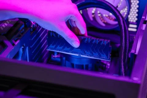 Installing RAM memory module into motherboard inside gaming computer, rgb l.. Stock-Fotos