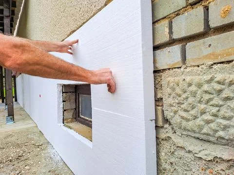 Installing rigid styrofoam insulation board for energy saving of the house wall Stock Photos
