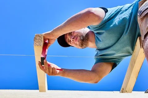Installing roof rafters while aligning chalk line with spirit level during .. Stock Photos