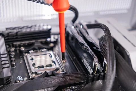 Installing screw with screwdriver, computer assembly process, close-up of mot Stock Photos