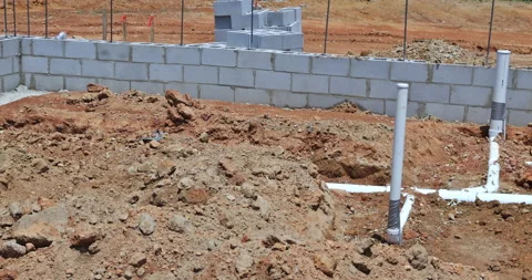 Installing sewer and water pipes in the ground under the foundation of a new Stock Footage 201533070