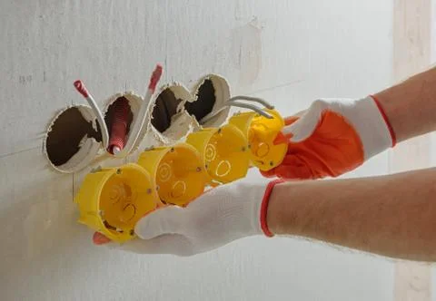Installing socket boxes into drywall. Stock Photos