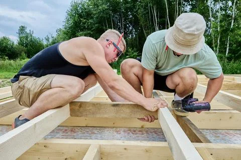 Installing spacer block during floor framing, builders secure blocking with.. Stock Photos